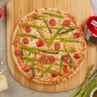 Pizza topped with asparagus and tomatoes