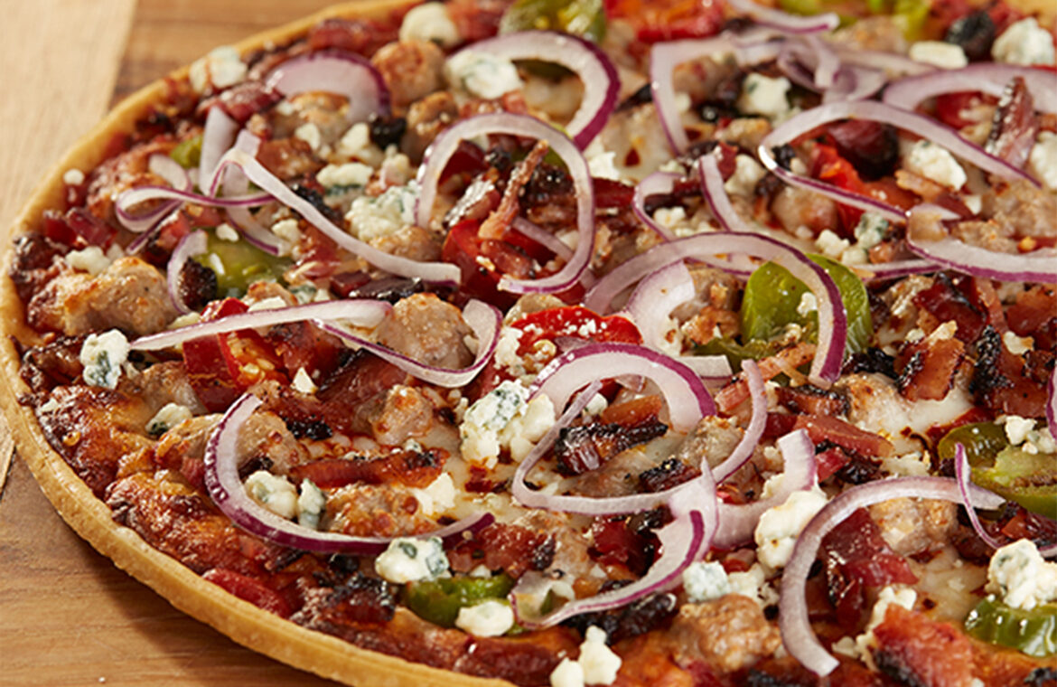 Pizza topped with red onions and mroe