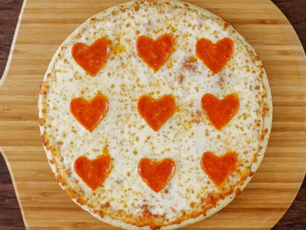 Pizza topped with heart shaped pepperoni