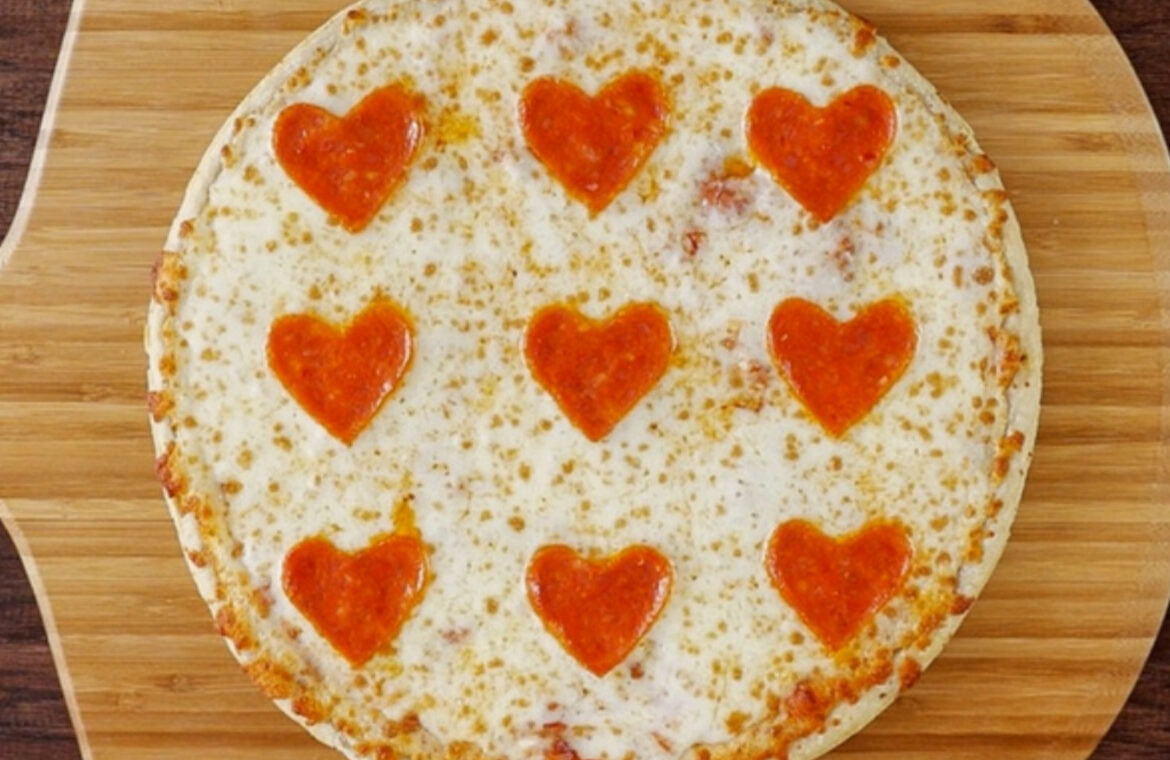 Pizza topped with heart shaped pepperoni