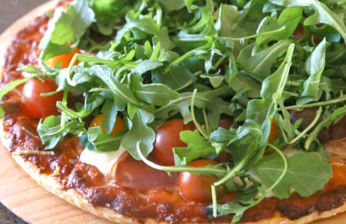 Pizza topped with cherry tomatoes and arugula