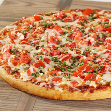 Pizza topped with diced tomatoes chili pepper flakes and fresh basil