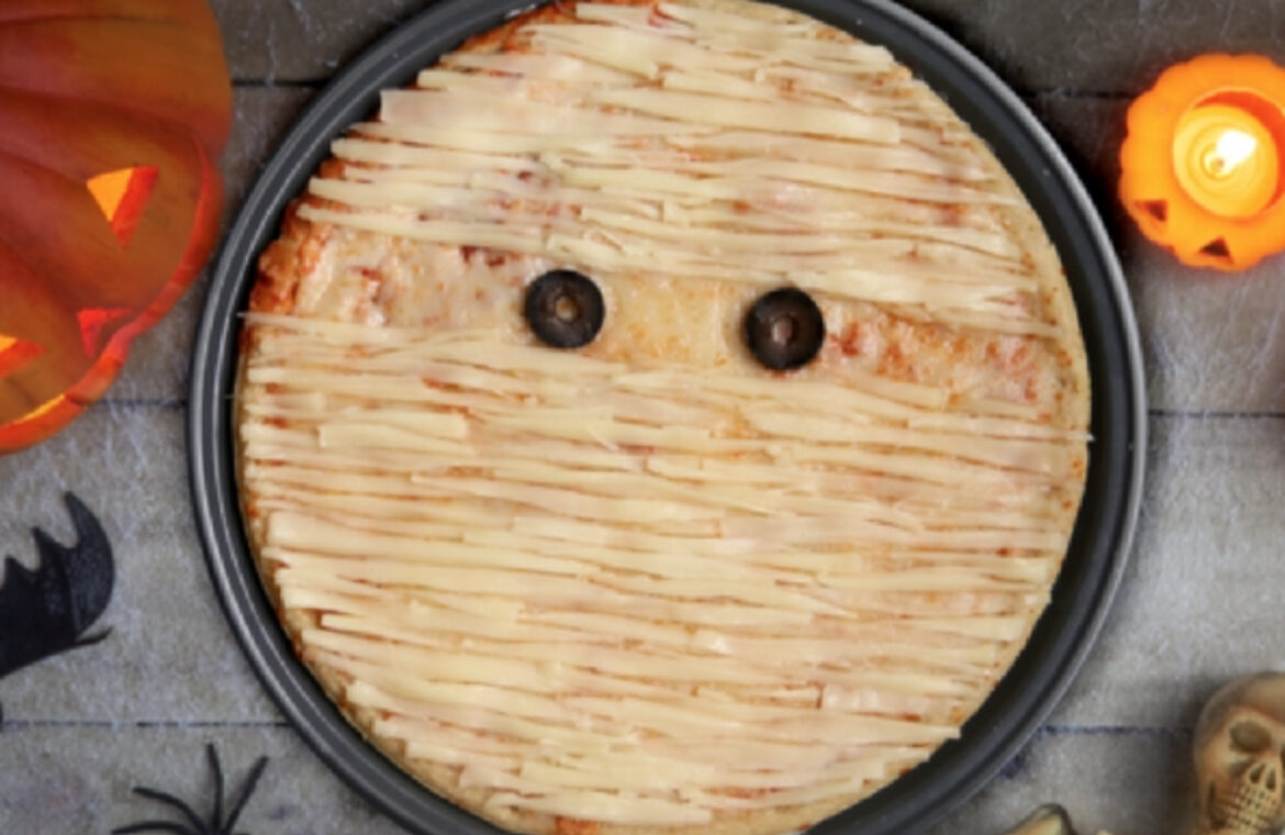pizza decorated with cheese to look like a mummy with olives for eyes