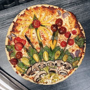 Pizza Topped with vegetables in the shape of flowers