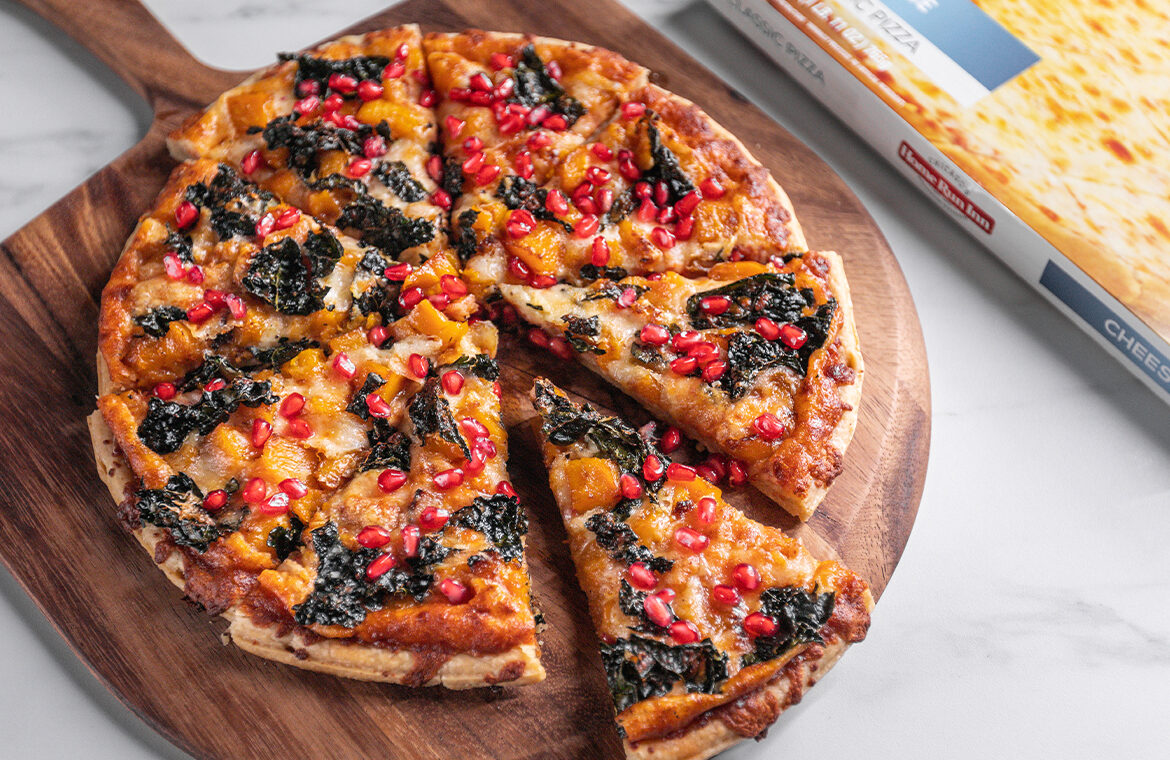 Pizza topped with pomegranate, kale, and squash