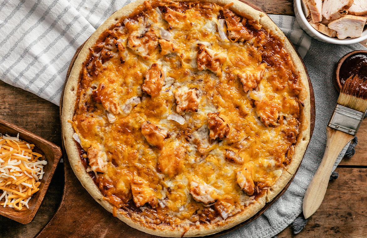 Pizza topped with BBQ sauce, chicken and cheese