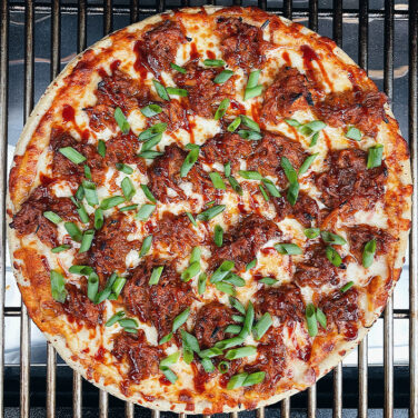 Pizza topped with BBQ Pulled Pork and green onions