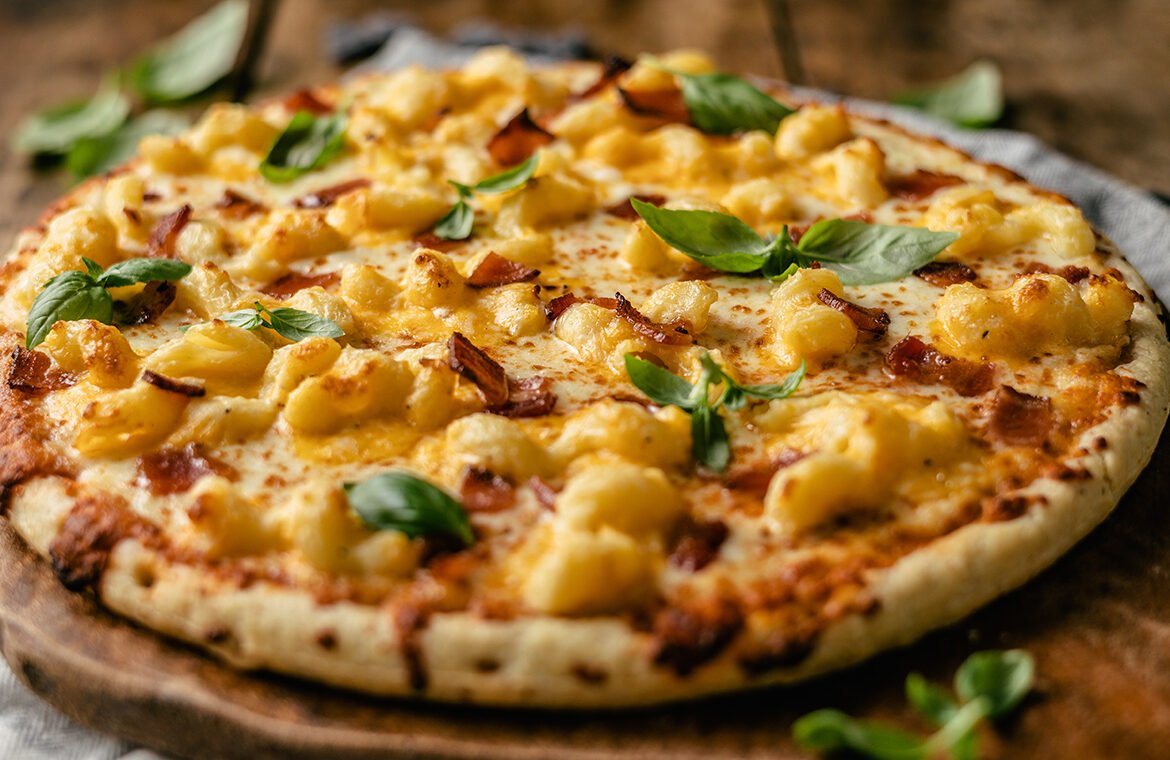 Pizza topped with bacon and mac n cheese