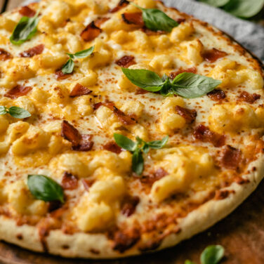 Pizza topped with bacon and mac n cheese