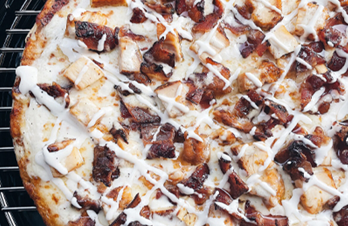 Pizza topped with chicken, bacon, and ranch