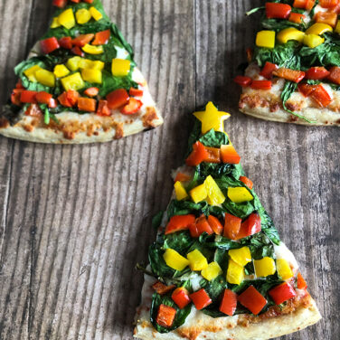 Pizza slices individually decorated to look like a Christmas tree