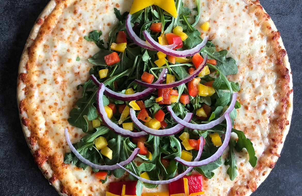 Pizza decorating with topping in the shape of a large Christmas tree