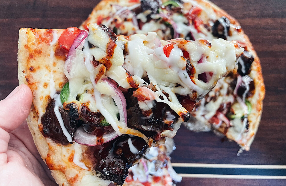 Grilled pizza topped with brisket and other toppings