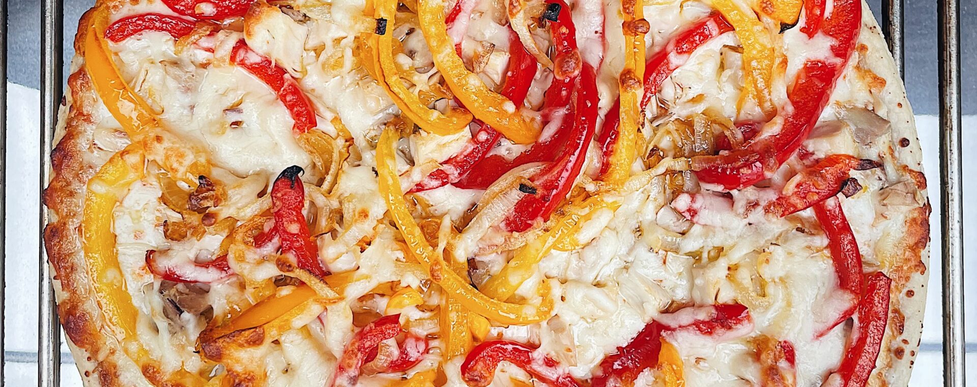 Pizza topped with peppers on the grill