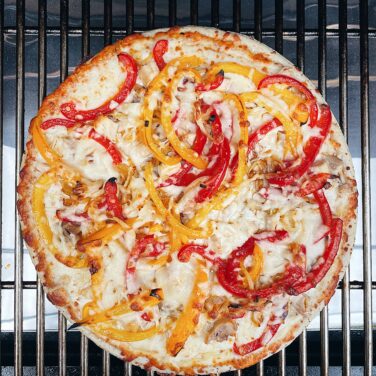Pizza topped with peppers on the grill