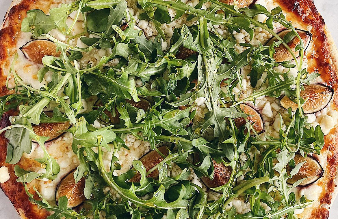 Pizza topped with fig and arugula