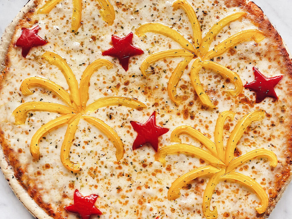 Pizza topped with peppers in the shape of fireworks and stars