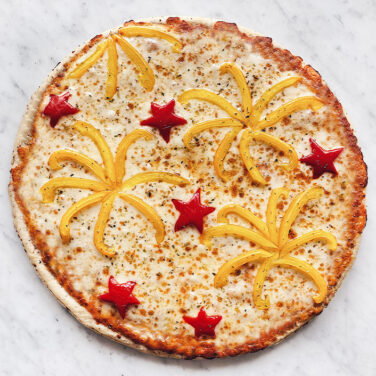 Pizza topped with peppers in the shape of fireworks and stars