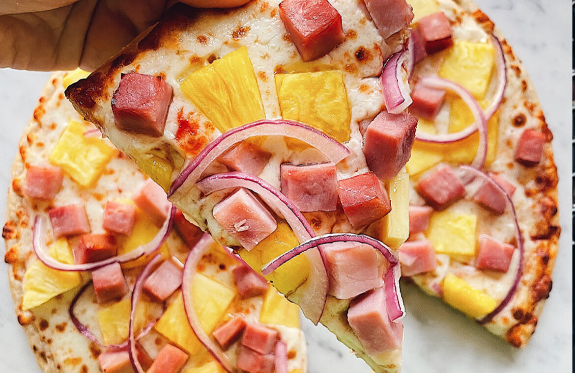 Pizza topped with pineapple, red onion, and ham
