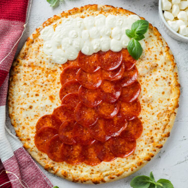 Pizza topped with ingredients in the shape of a christmas stocking
