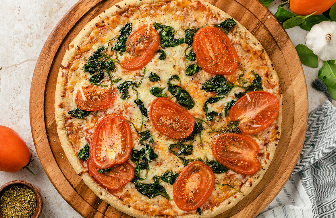 Pizza topped with tomatoes and spinach