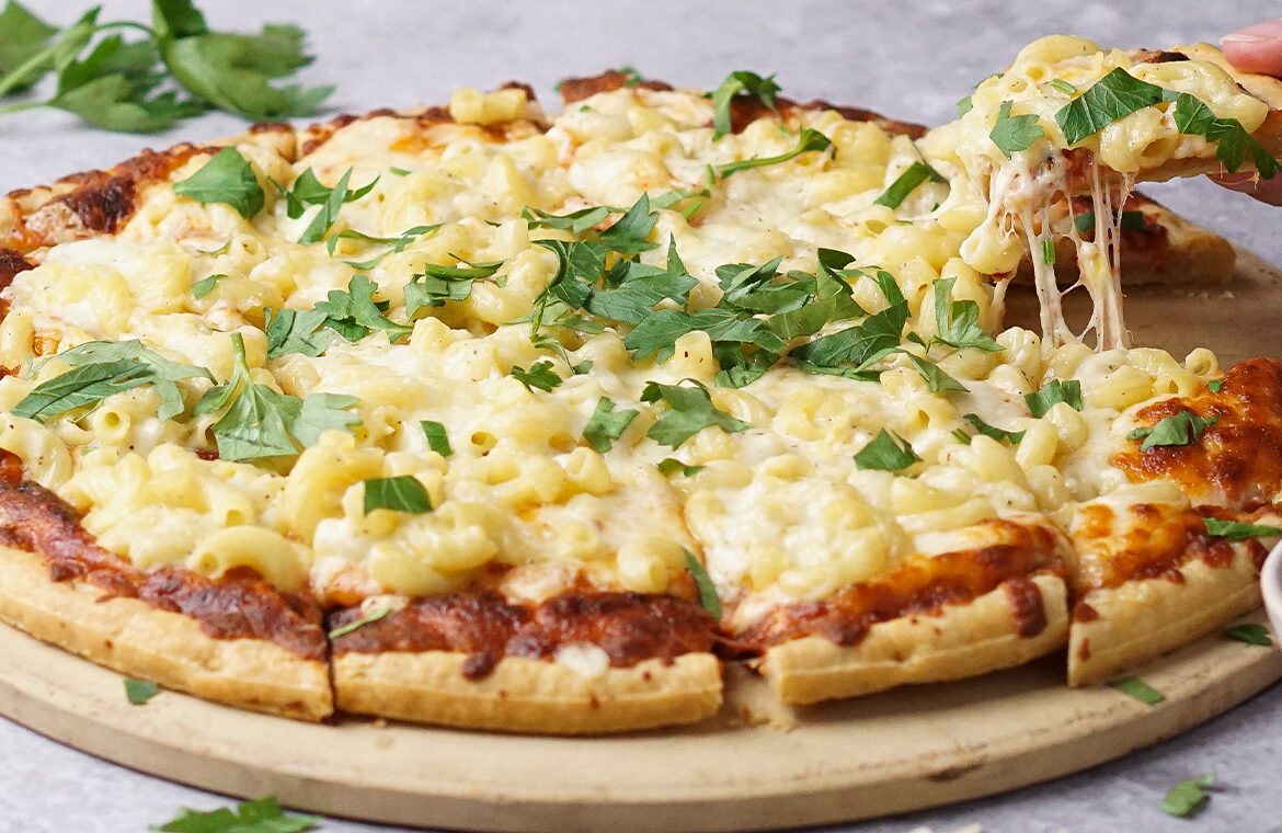 Pizza topped with macaroni and cilantro