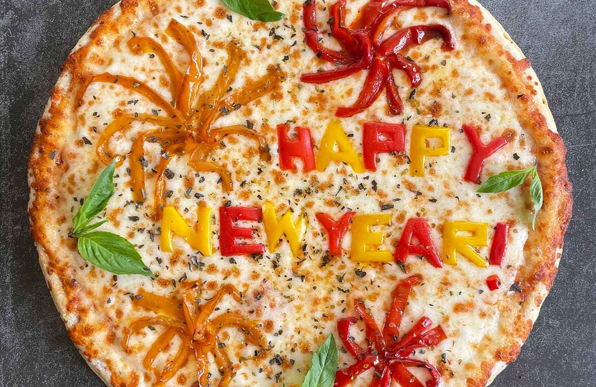 Pizza with toppings spelling out "Happy New Year"
