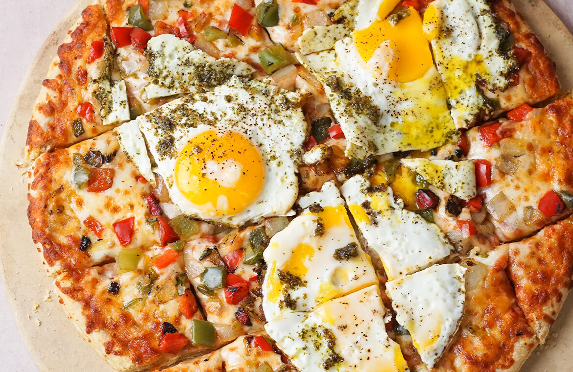 Veggie pizza topped with egg and pesto