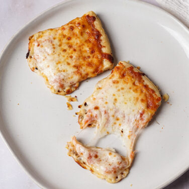 Heated up pizza with melty cheese on a plate