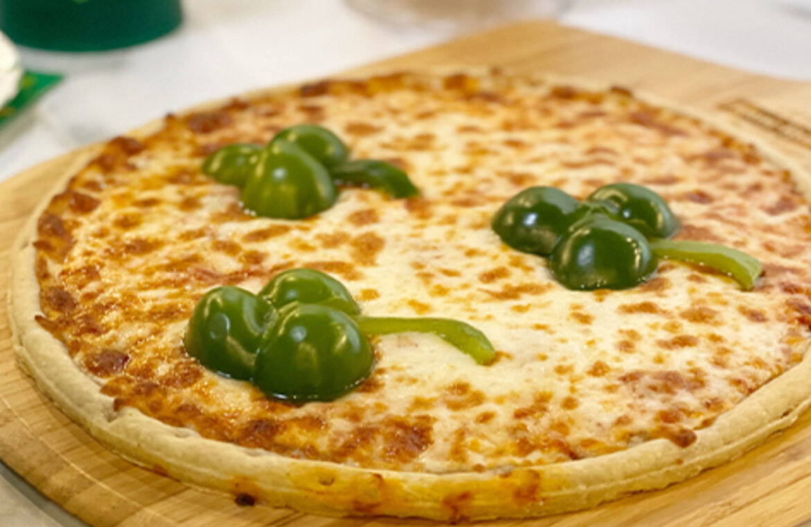 Pizza topped with peppers in the shape of a clover