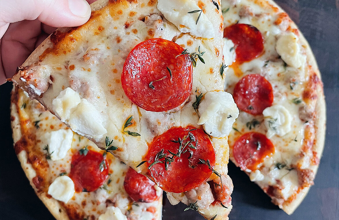 Sausage Pepperoni Pizza topped with hot honey, thyme, and riccota
