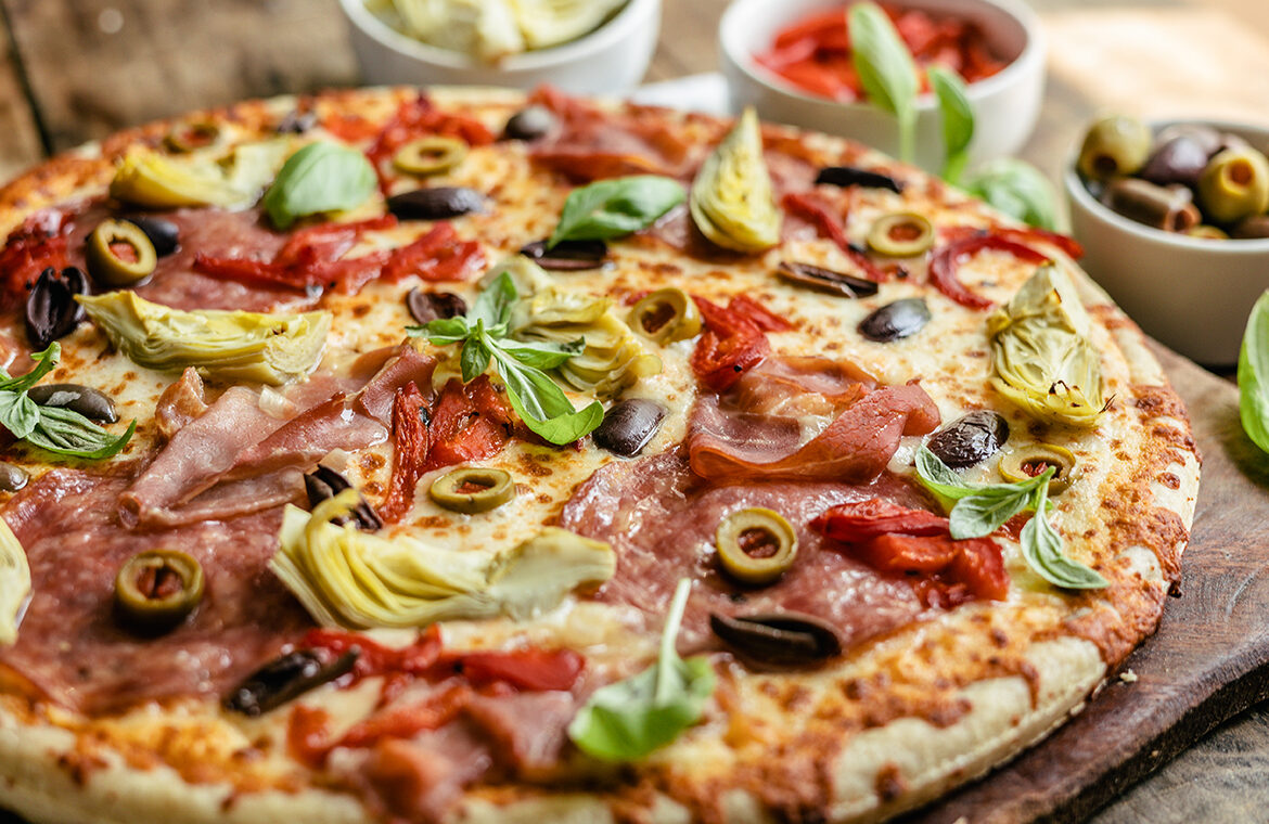 pizza topped with charcuterie board ingredients to resemble a snacking board