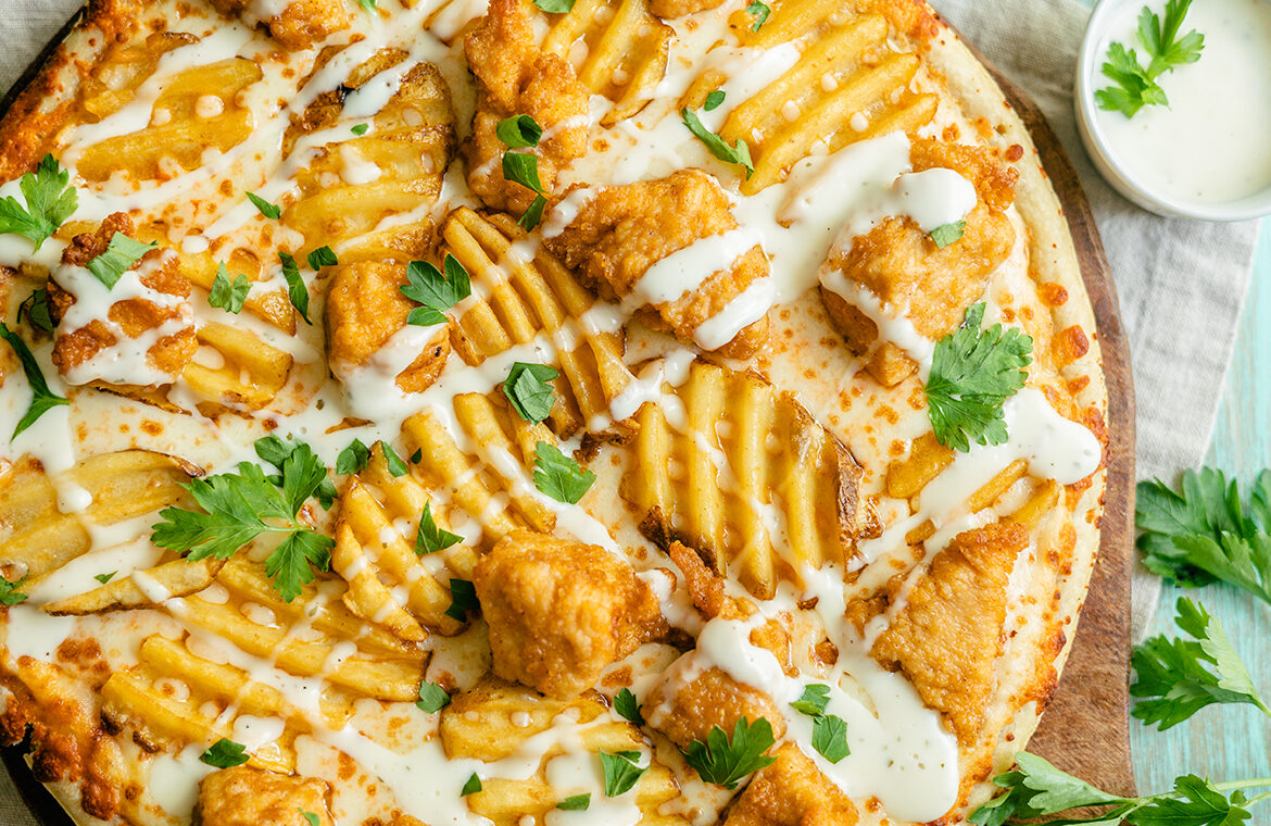 Pizza topped with chicken nuggets and waffle fries