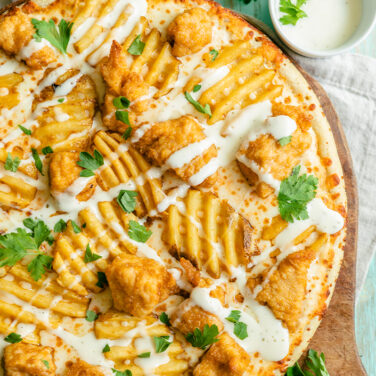 Pizza topped with chicken nuggets and waffle fries