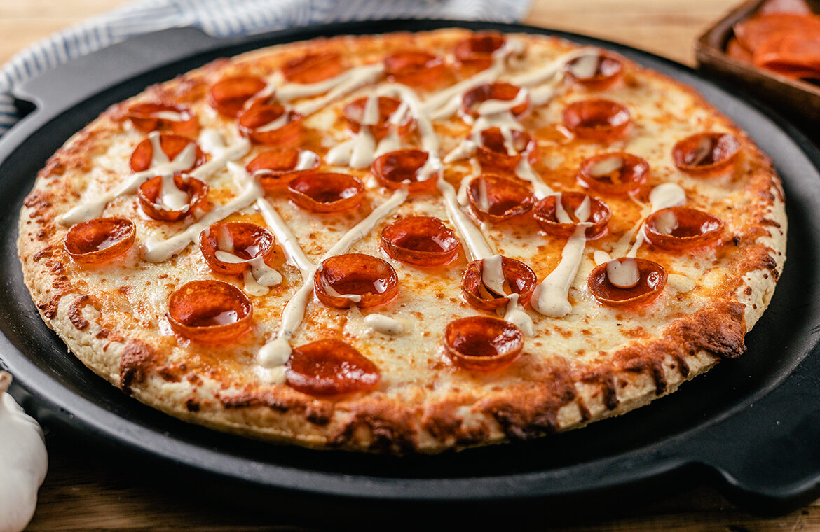 Pizza topped with cupped pepperoni and garlic aioli drizzle