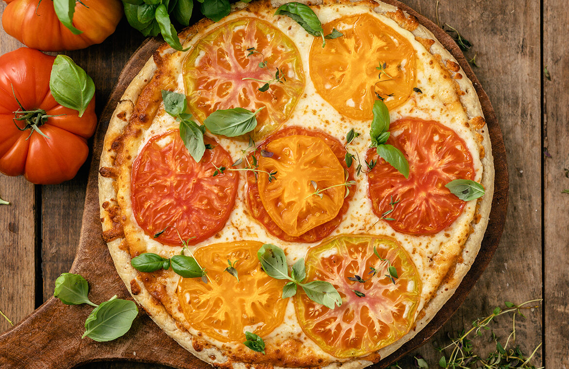 pizza topped with heirloom tomatoes and fresh basil