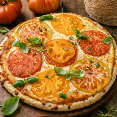 pizza topped with heirloom tomatoes and fresh basil