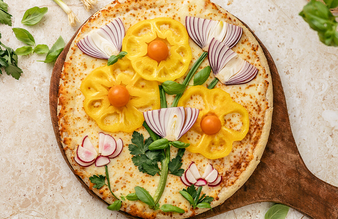 pizza topped with veggies in the shape of flowers