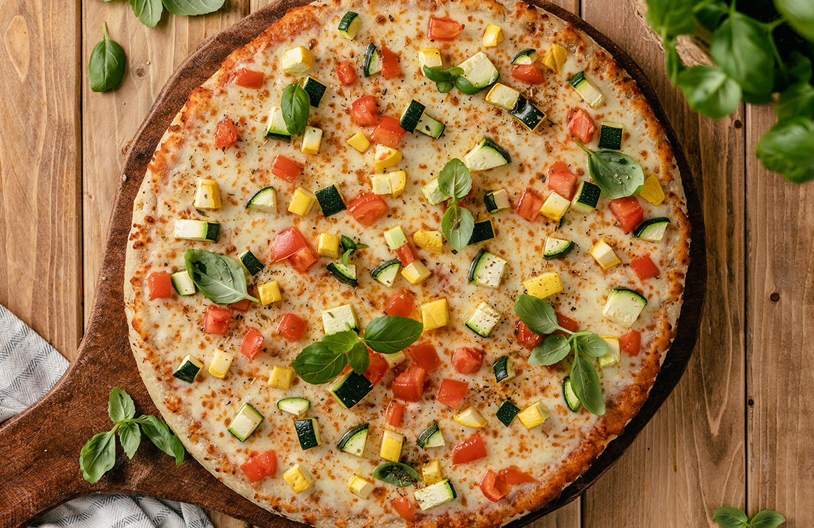 pizza topped with zucchini, squash, and more