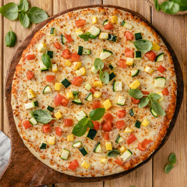 pizza topped with zucchini, squash, and more