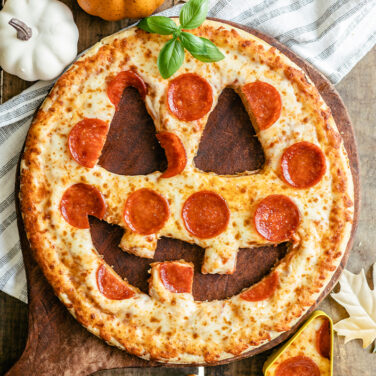 Pizza with pieces cut out to look like a jack-o-lantern