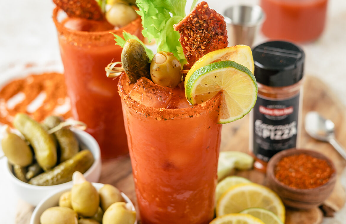 Bloody Mary loaded up with ingredients and rimmed with pizza seasoning