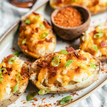 Double baked potatoes topped with cheese, bacon, green onion, and pizza seasoning