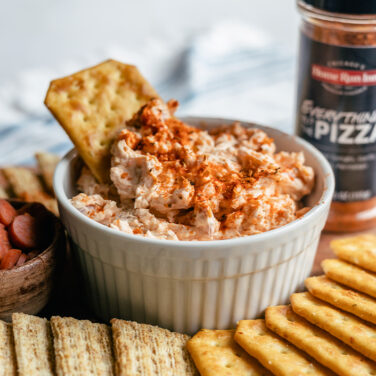 Cracker being dipped into Pizza dip