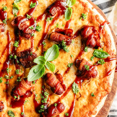 Pizza topped with bacon wrapped smokies