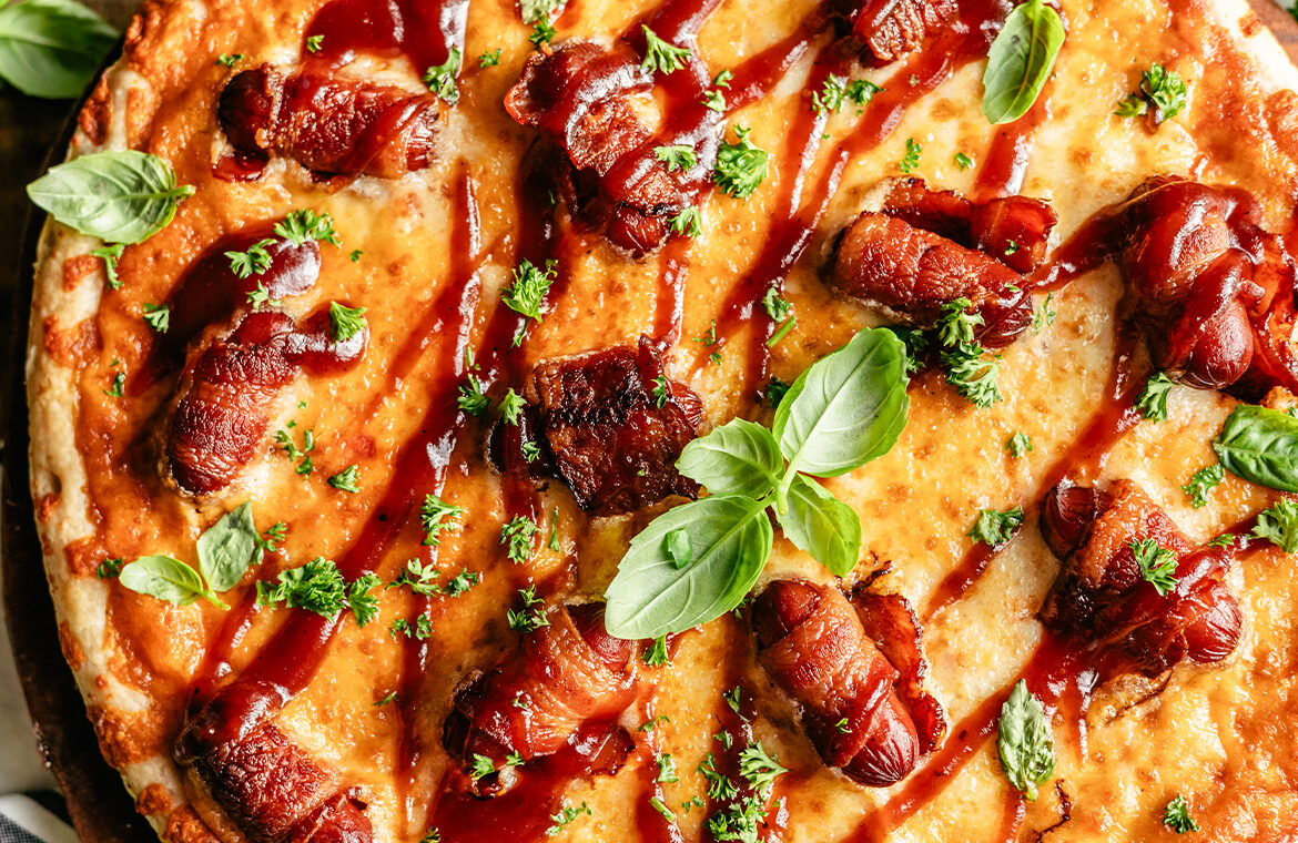 Pizza topped with bacon wrapped smokies