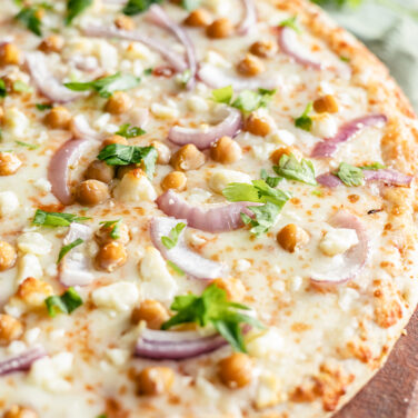Pizza topped with chickpeas, red onion, and feta