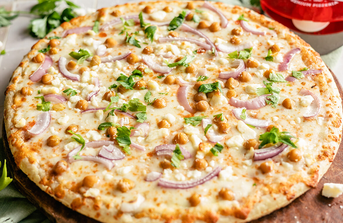Pizza topped with chickpeas, red onion, and feta