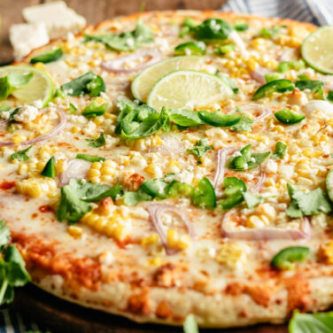 Pizza topped with corn, limes, cilantro, and more