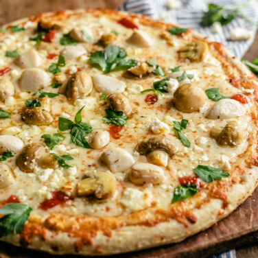 Pizza topped with mushrooms, feta, and garlic